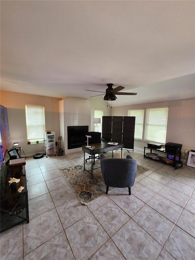 living room featuring ceiling fan and a tile fireplace