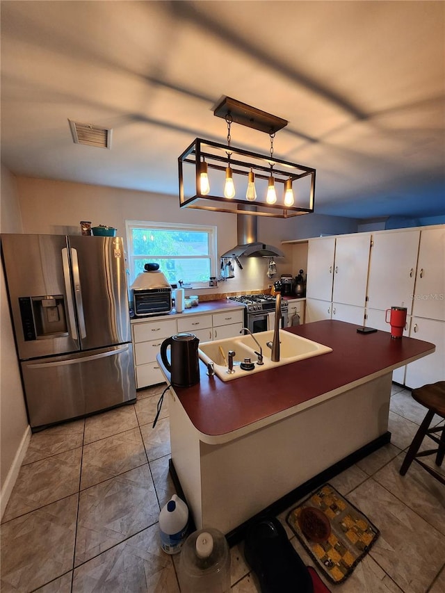 kitchen featuring white cabinets, hanging light fixtures, island exhaust hood, stainless steel appliances, and a breakfast bar area