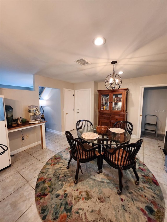 tiled dining space with a chandelier