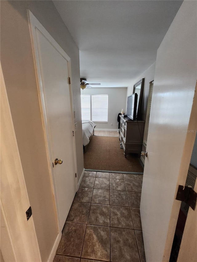 hall featuring dark tile patterned floors