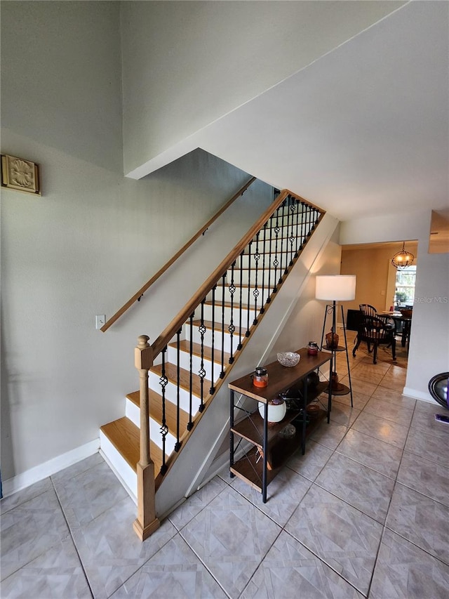 stairway with a notable chandelier