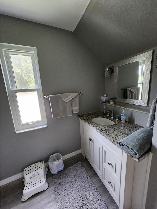 bathroom featuring lofted ceiling, hardwood / wood-style flooring, and vanity