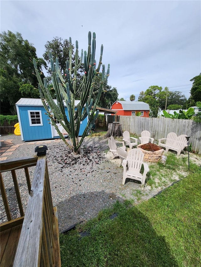 view of yard featuring a storage unit and an outdoor fire pit