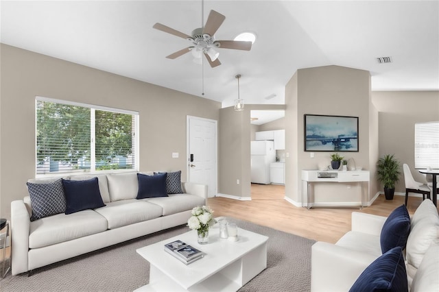 living room with light hardwood / wood-style floors, vaulted ceiling, and ceiling fan