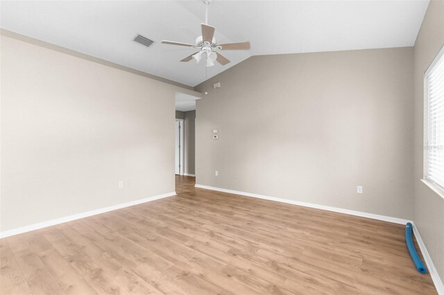 spare room featuring ceiling fan, light wood-type flooring, and lofted ceiling