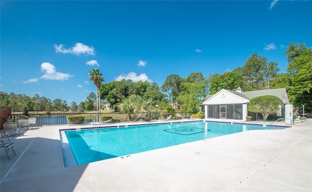 view of pool featuring a patio area, a sunroom, and a water view