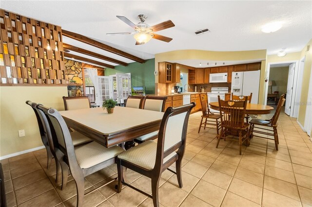 tiled dining space featuring beamed ceiling, ceiling fan, and a textured ceiling