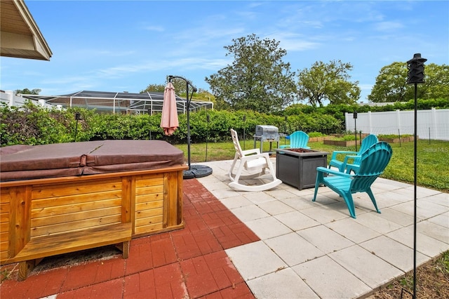 view of patio / terrace with a lanai, a hot tub, a fire pit, and a grill