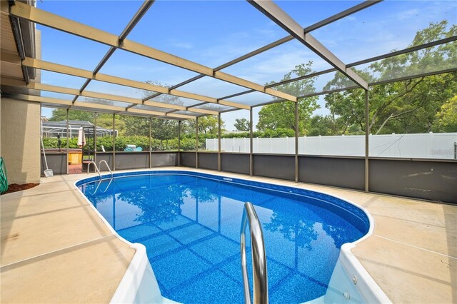 view of swimming pool with a patio and glass enclosure