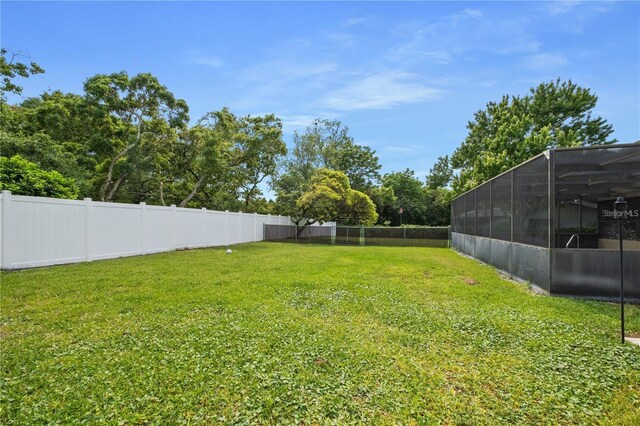 view of yard featuring glass enclosure