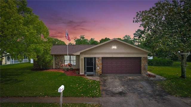 ranch-style house featuring a yard and a garage