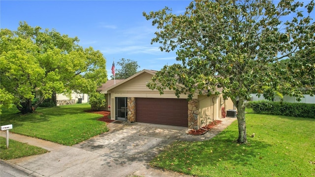 view of front of house featuring a front yard, central AC unit, and a garage