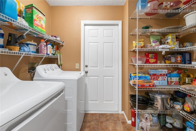 laundry room featuring tile patterned flooring, washing machine and clothes dryer, and a textured ceiling