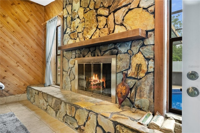 interior details with a fireplace, wood walls, and tile patterned flooring