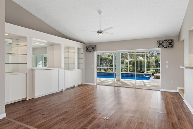 interior space featuring a textured ceiling, ceiling fan, lofted ceiling, and hardwood / wood-style flooring