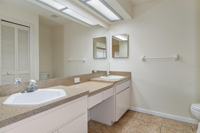 bathroom with toilet, tile patterned flooring, and vanity