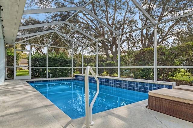 view of swimming pool with glass enclosure and a patio area