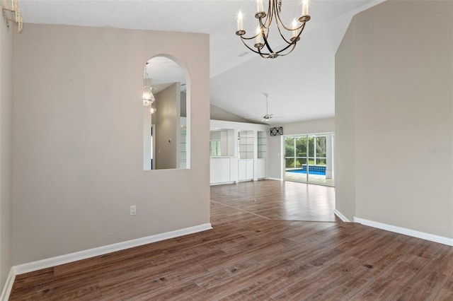 interior space with ceiling fan with notable chandelier, dark hardwood / wood-style flooring, and lofted ceiling