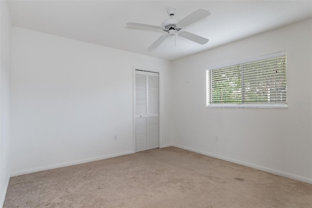 carpeted empty room featuring ceiling fan