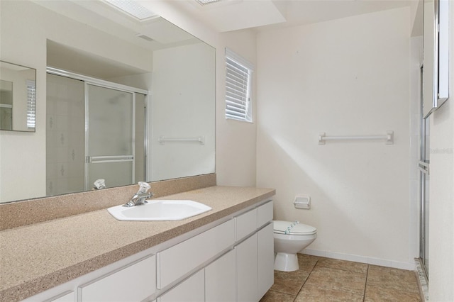 bathroom featuring toilet, a shower with door, tile patterned floors, and vanity