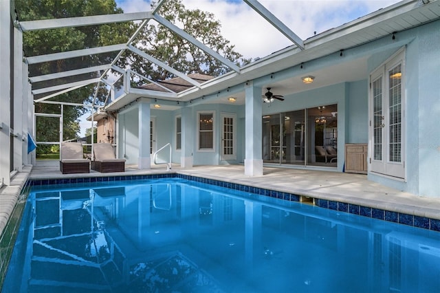 view of pool with ceiling fan, glass enclosure, cooling unit, and a patio