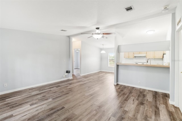 14904 Old Dixie Hwy, Hudson, FL 34667 - unfurnished living room featuring wood finished floors, visible vents, lofted ceiling, and ceiling fan