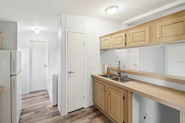 14904 Old Dixie Hwy, Hudson, FL 34667 - kitchen with light countertops, a sink, light wood-type flooring, light brown cabinetry, and freestanding refrigerator