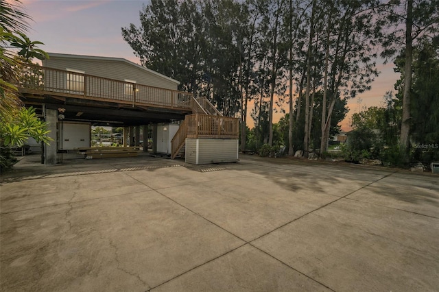 property exterior at dusk featuring a wooden deck