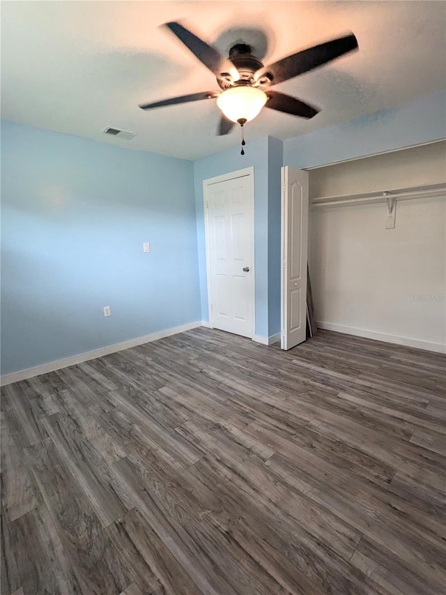 unfurnished bedroom with a closet, ceiling fan, and dark hardwood / wood-style flooring