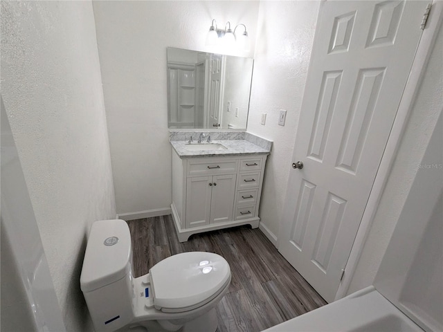 bathroom featuring hardwood / wood-style flooring, toilet, and vanity