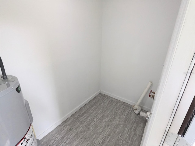 washroom with light wood-type flooring and water heater