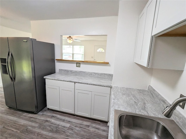 kitchen with light hardwood / wood-style floors, sink, white cabinets, ceiling fan, and stainless steel fridge