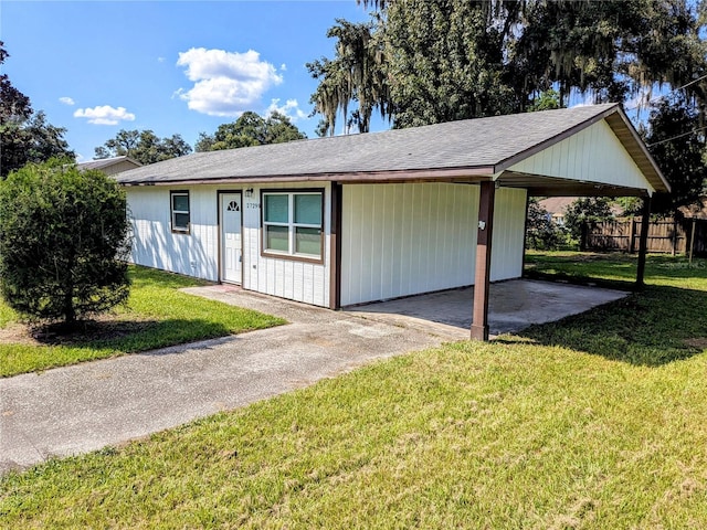 view of front of home with a carport and a front lawn