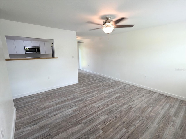 unfurnished living room featuring hardwood / wood-style floors and ceiling fan