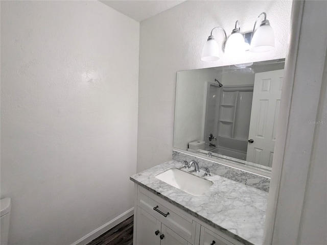 full bathroom with hardwood / wood-style flooring, toilet, bathtub / shower combination, and vanity