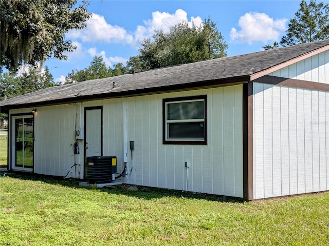 exterior space with central air condition unit and a lawn