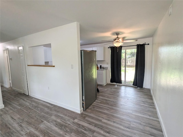 kitchen with light hardwood / wood-style floors, white cabinets, ceiling fan, and stainless steel refrigerator