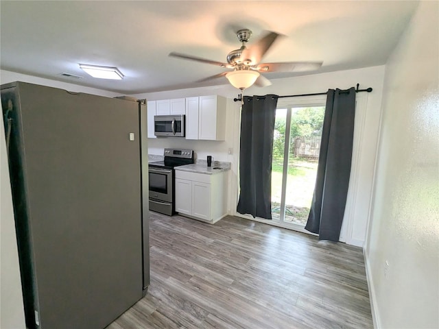 kitchen featuring white cabinets, light hardwood / wood-style flooring, ceiling fan, and stainless steel appliances