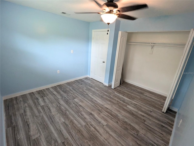 unfurnished bedroom featuring ceiling fan, a closet, and dark hardwood / wood-style flooring