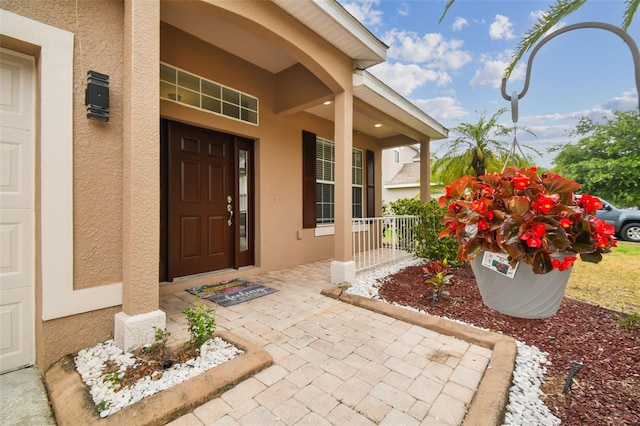 doorway to property with stucco siding and a porch