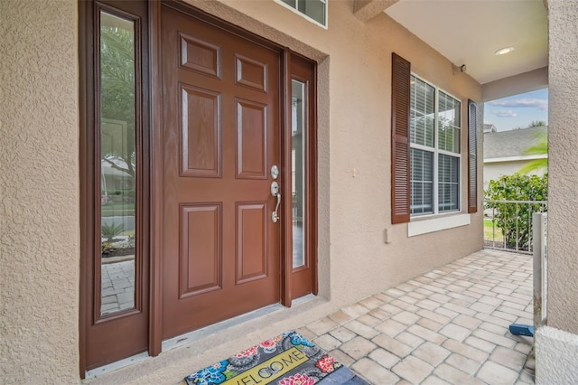 entrance to property featuring stucco siding