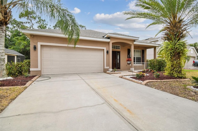 view of front facade with stucco siding, an attached garage, and driveway