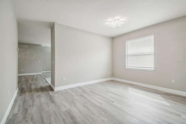 empty room featuring light wood-style flooring and baseboards