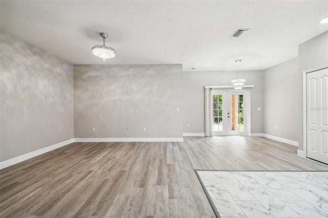 interior space with visible vents, light wood-type flooring, and baseboards