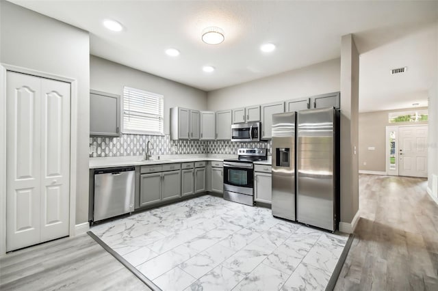 kitchen with visible vents, gray cabinets, a sink, stainless steel appliances, and a wealth of natural light