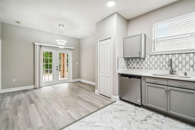 kitchen featuring a sink, gray cabinetry, light countertops, french doors, and stainless steel dishwasher