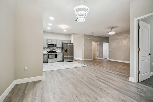 kitchen featuring appliances with stainless steel finishes, baseboards, and light wood-style floors