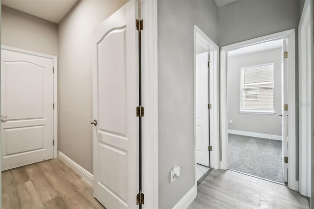 hallway featuring baseboards and light wood-style floors