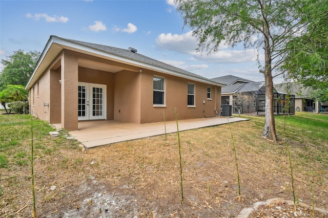 back of house featuring central air condition unit, stucco siding, a patio, french doors, and a yard