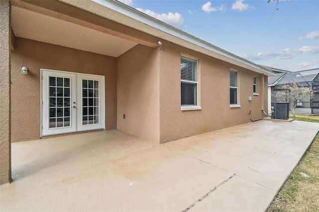 view of patio / terrace with glass enclosure, french doors, and central AC